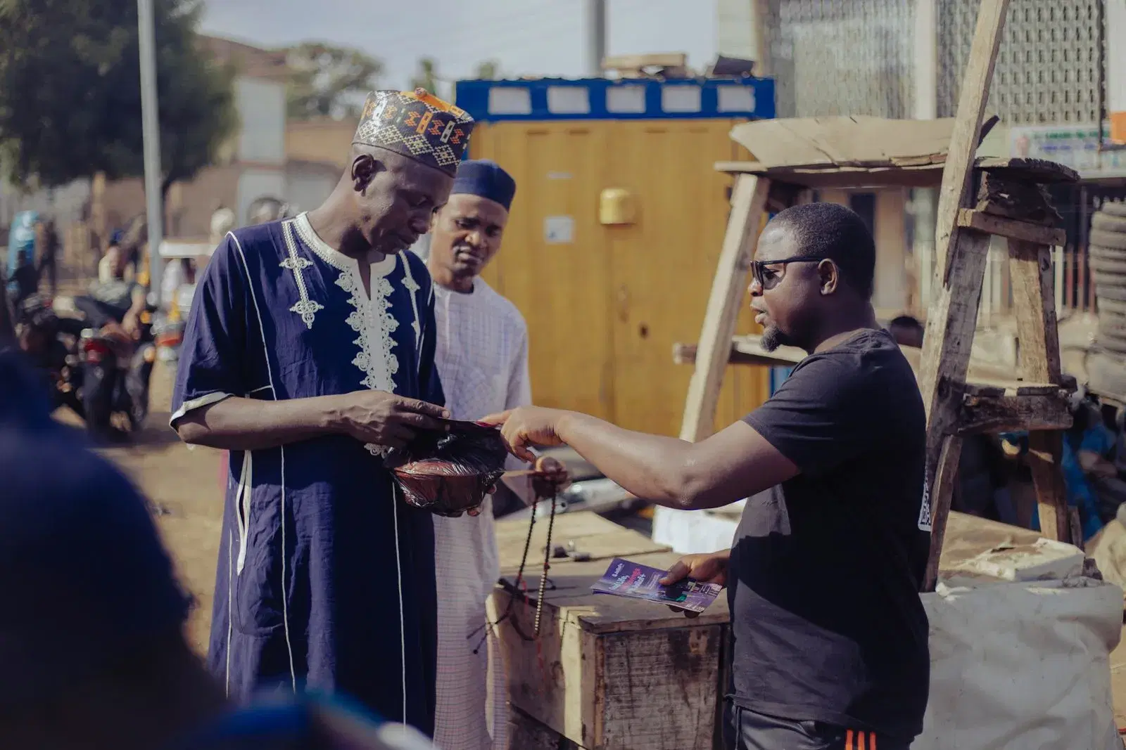 Community members completing a cash transaction with a local agent on the street